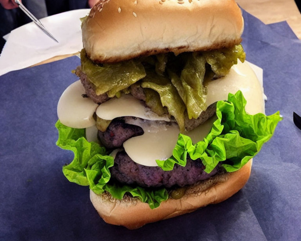 Giant multi-patty cheeseburger with lettuce, pickles, sesame bun