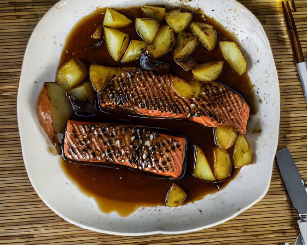 Salmon Fillets and Roasted Potatoes on White Plate with Sauce, Wooden Table Setting