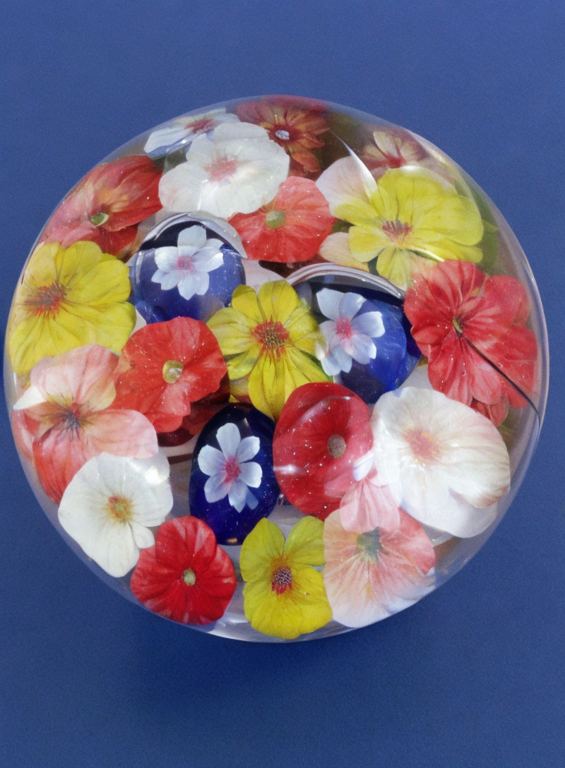 Colorful Realistic Flower Inclusions in Round Paperweight on Blue Background