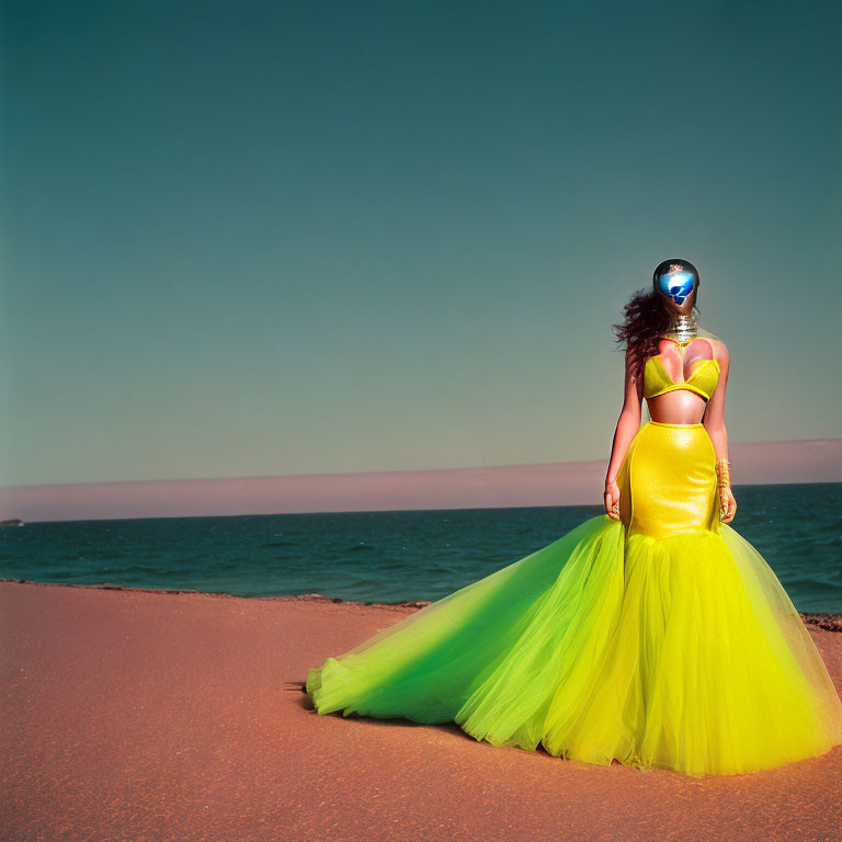 Woman in Vibrant Yellow Dress and Futuristic Silver Mask on Beach
