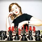 Stylized image of pale woman in black attire with chess pieces
