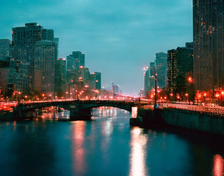 Cityscape at Twilight: Illuminated Buildings, River Reflections, Bridge, Hazy Sky