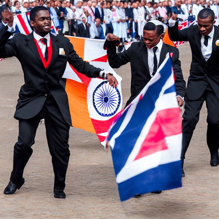 Men in suits waving Indian and British flags at outdoor event