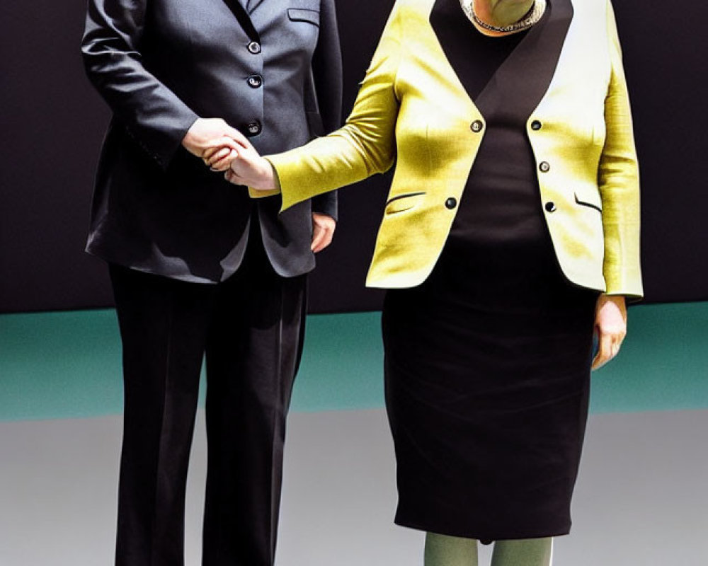 Two figures in black and green outfits standing together.