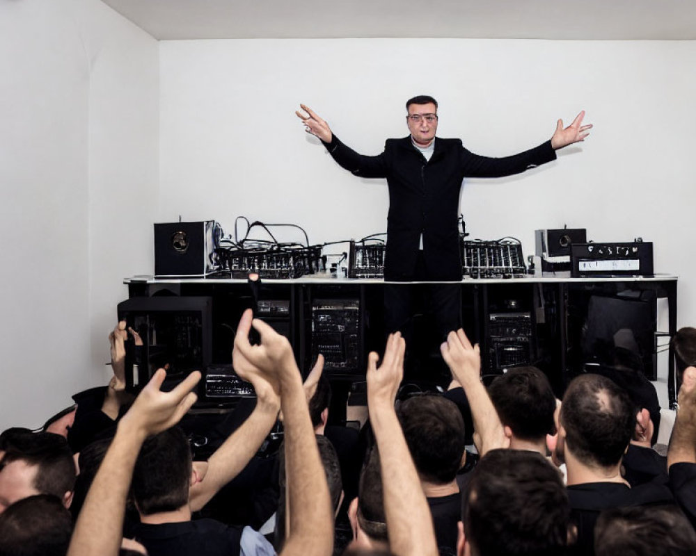 Man with raised arms at DJ booth in lively party with crowd