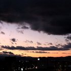 Scenic sunset panorama with silhouetted mountains and town lights