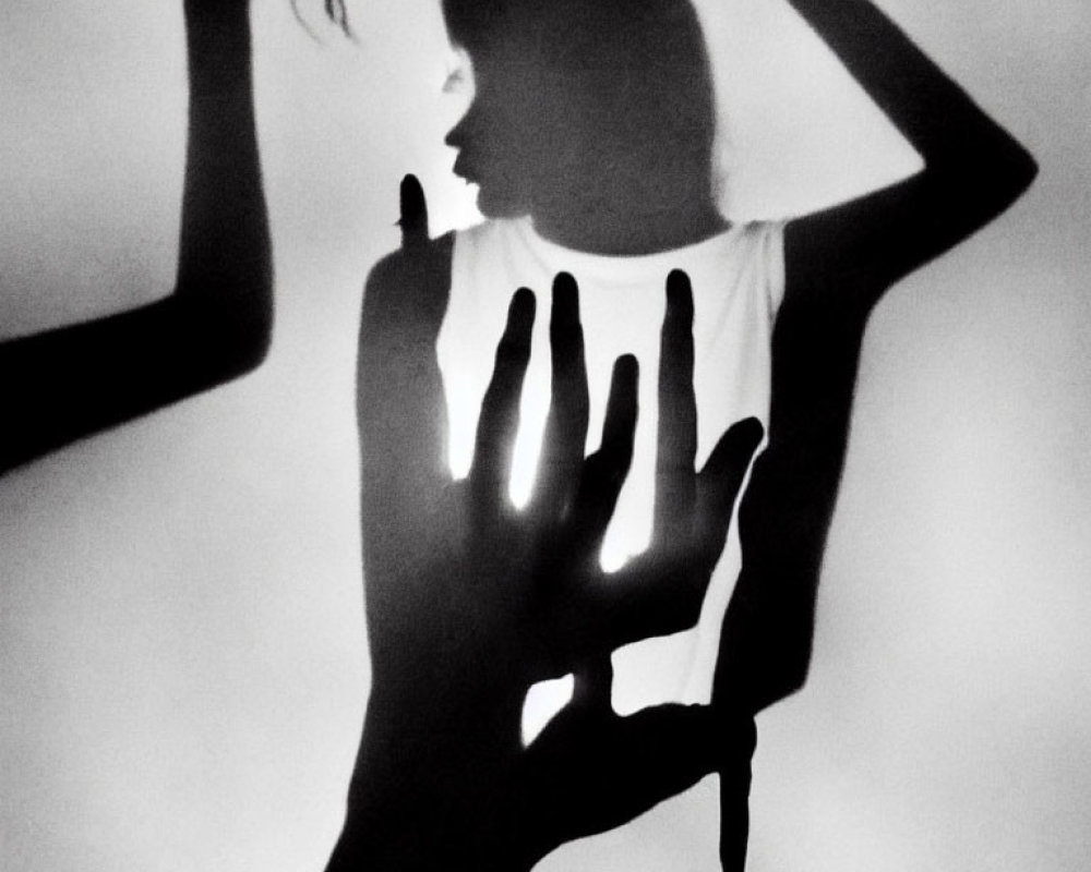 Monochrome image of silhouetted figure with dramatic shadows