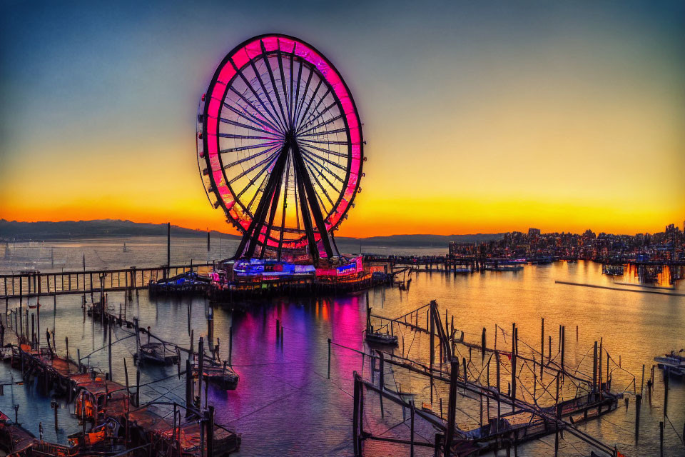 Vibrant sunset behind illuminated Ferris wheel and harbor scene