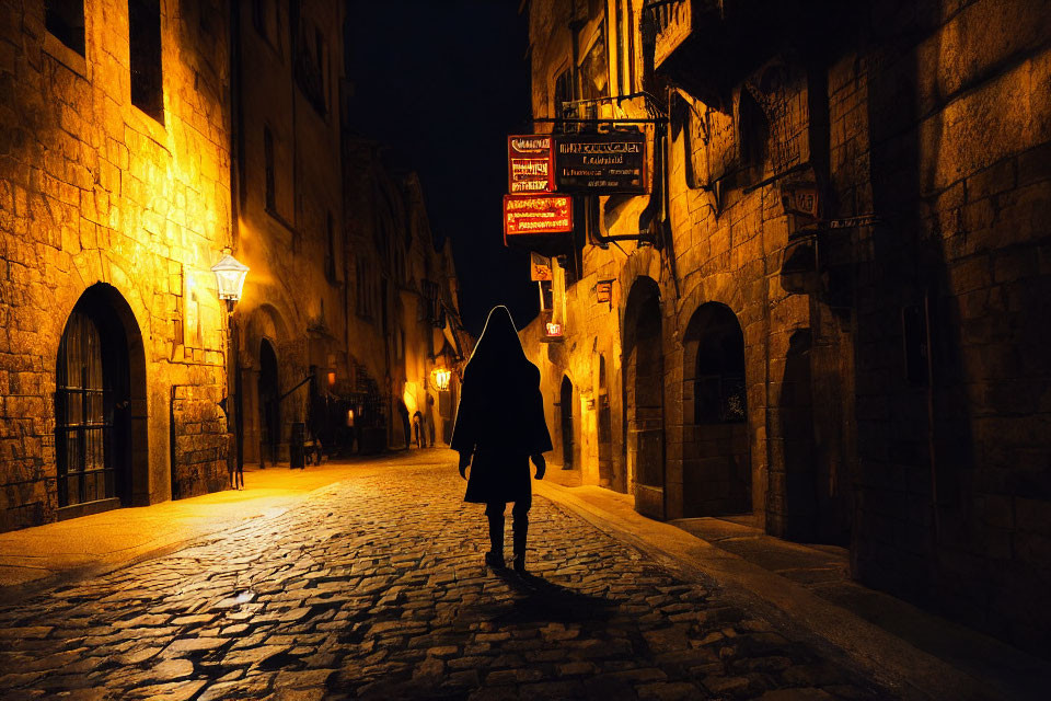 Solitary figure walking on dimly lit cobblestone street at night