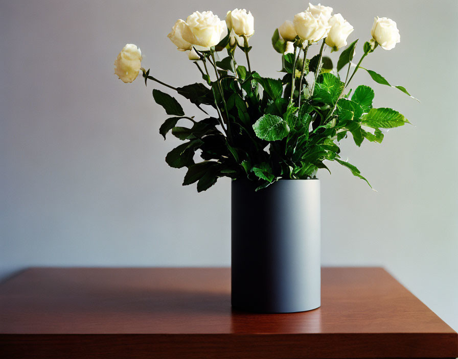 White Roses Bouquet in Gray Vase on Wooden Table
