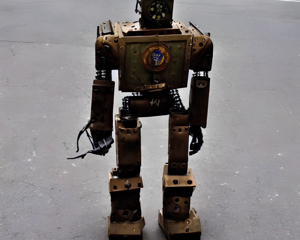 Realistic bipedal robot with rust-like finish and torso emblem on tarmac.