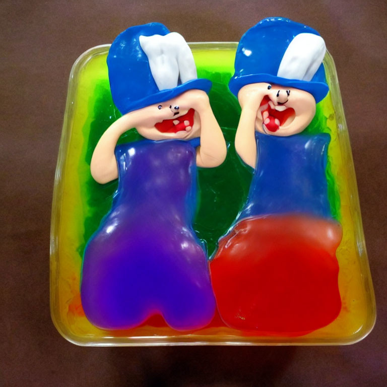 Cartoonish figures in blue hats and cloaks in colorful gelatin dessert