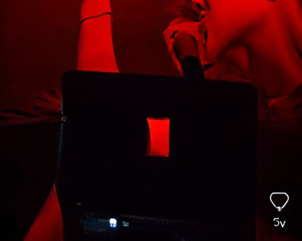 DJ performing with mixer under red lighting and "Transformeter" displayed on screen