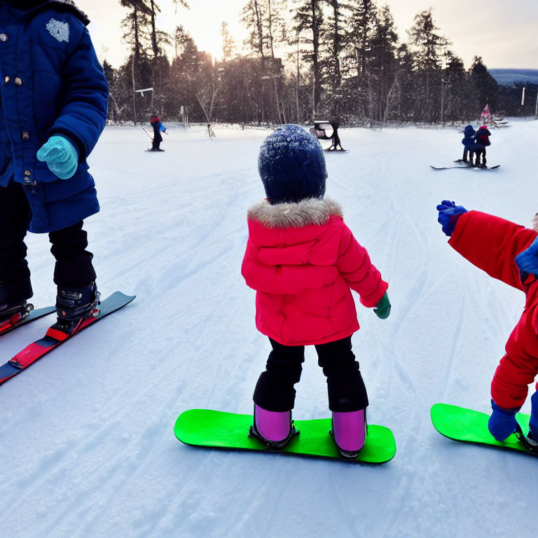 Child in Red Jacket Learning Snowboarding with Instructor on Snowy Slope