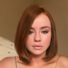 Young woman's digital portrait: short brown hair, blue eyes, gazing at viewer on beige backdrop