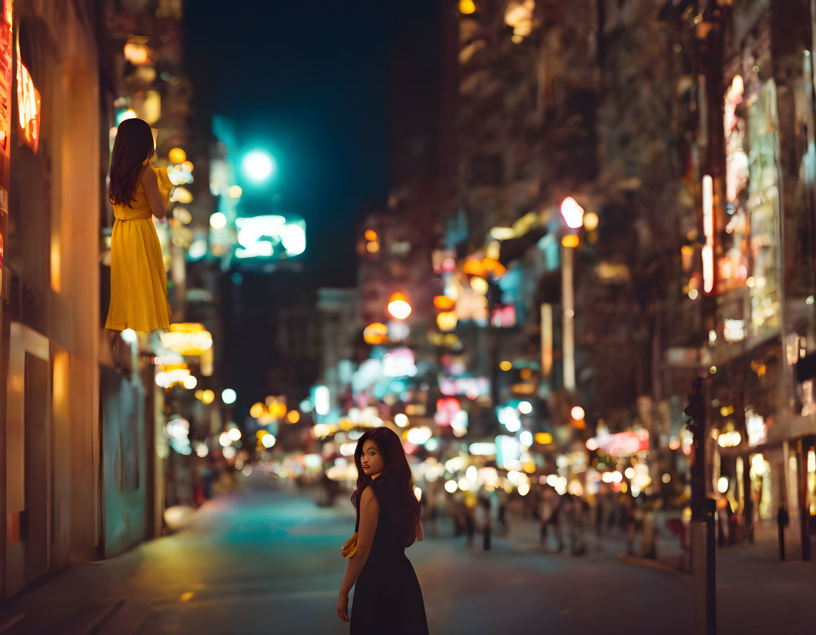 Two women in black and yellow dresses on city street at night