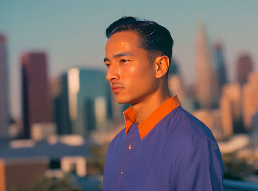 Man in Blue Shirt Contemplating City Skyline at Sunset