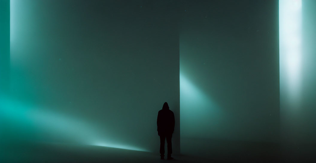 Mysterious figure in dark space with green-tinted lights