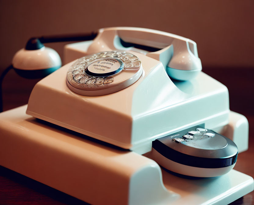 Classic rotary dial telephone on wooden surface with blurred background