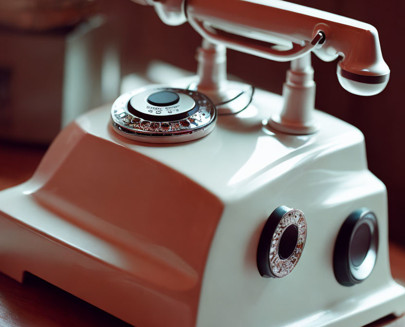 Classic Rotary Telephone with White Base on Wooden Surface