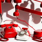 Vintage Red Telephones with Off-Hook Handsets on White Background