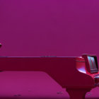 Blue-haired individual at red grand piano in purple-lit room