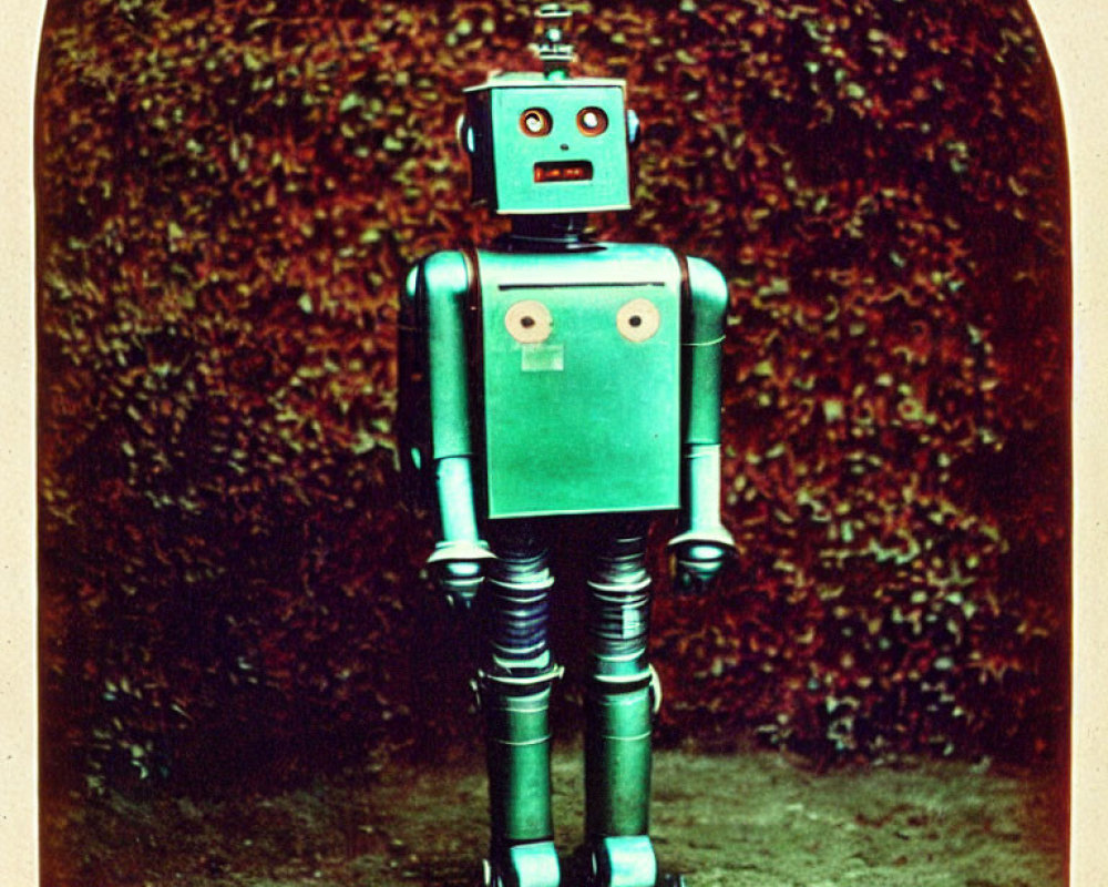 Vintage Toy Robot with Red Head and Green Body on Leafy Background