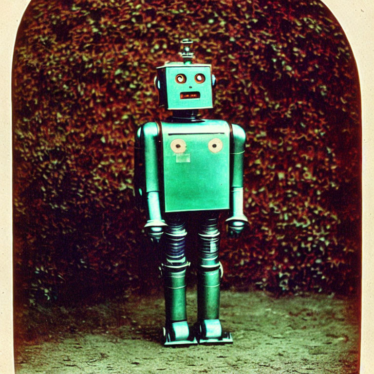 Vintage Toy Robot with Red Head and Green Body on Leafy Background