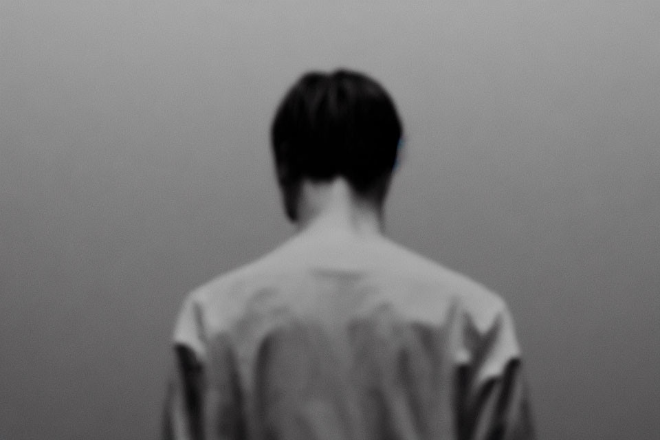 Monochrome image of person's back with blurry background