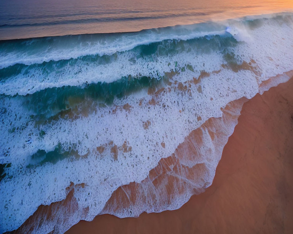 Aerial View of Sunset Shoreline with Rolling Waves and Sandy Beach