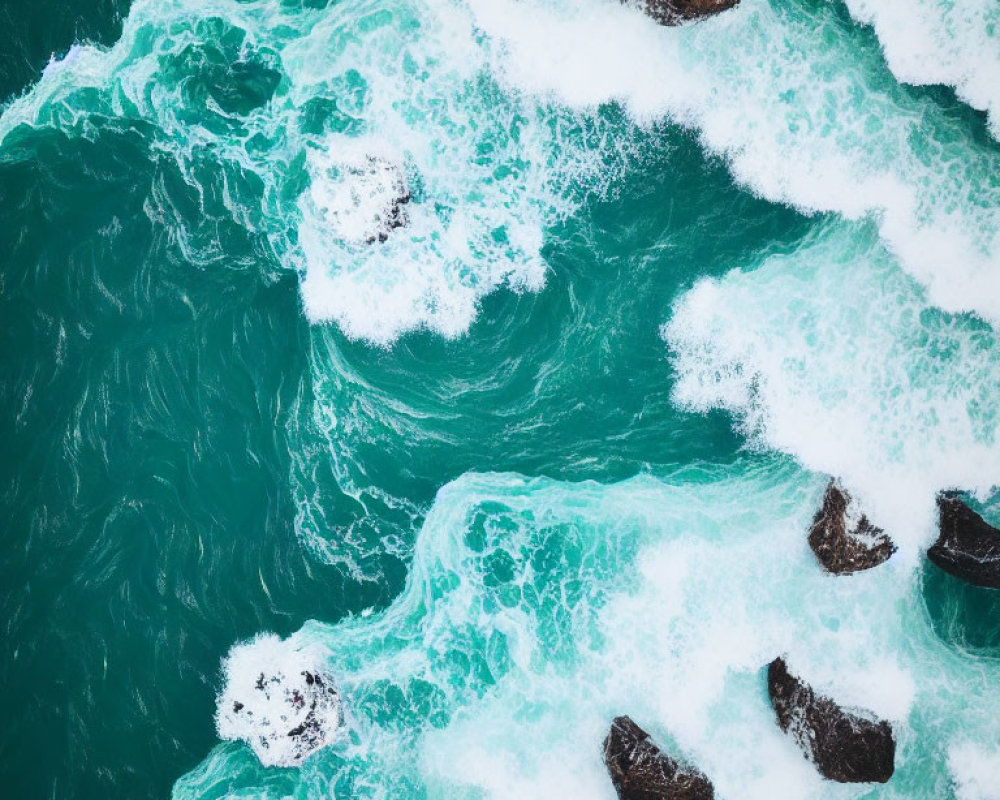 Aerial View: Turquoise Ocean Waves Crashing on Dark Rocks