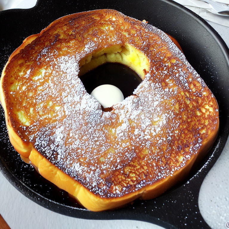 Circular Cutout French Toast with Powdered Sugar on Skillet