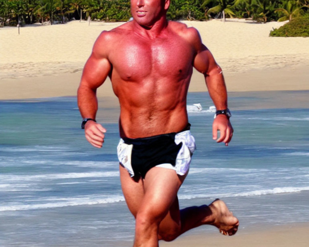 Muscular man jogging barefoot on sunny beach with palm trees.