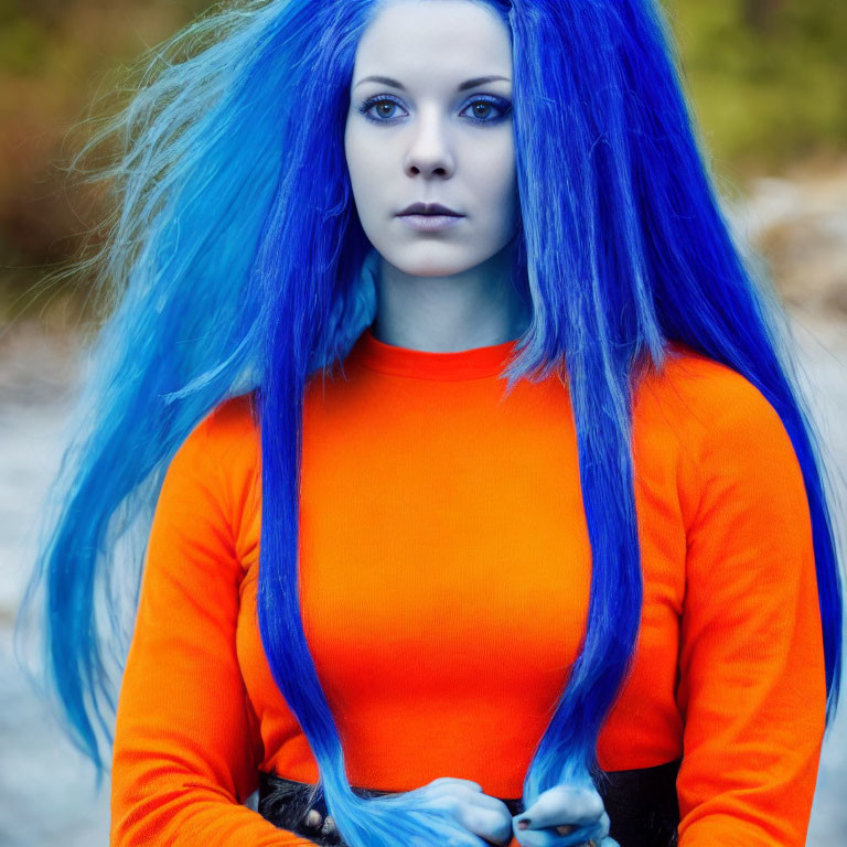 Vibrant blue-haired woman in orange top with intense gaze outdoors