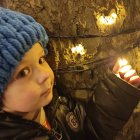 Child in Blue Beanie Observing Glowing Blue Mushroom and Magical Lights