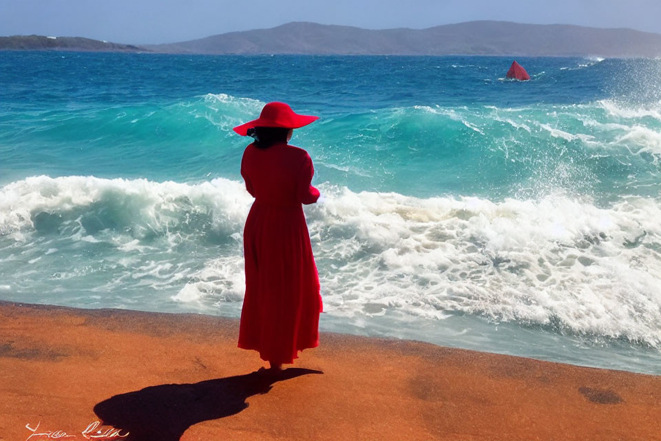 Woman in red dress and hat on beach watching waves and sailboat in the distance