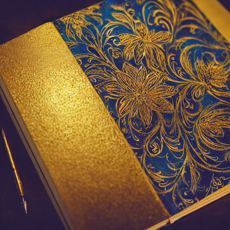 Blue and Gold Floral Pattern Journal with Golden Pen on Dark Surface
