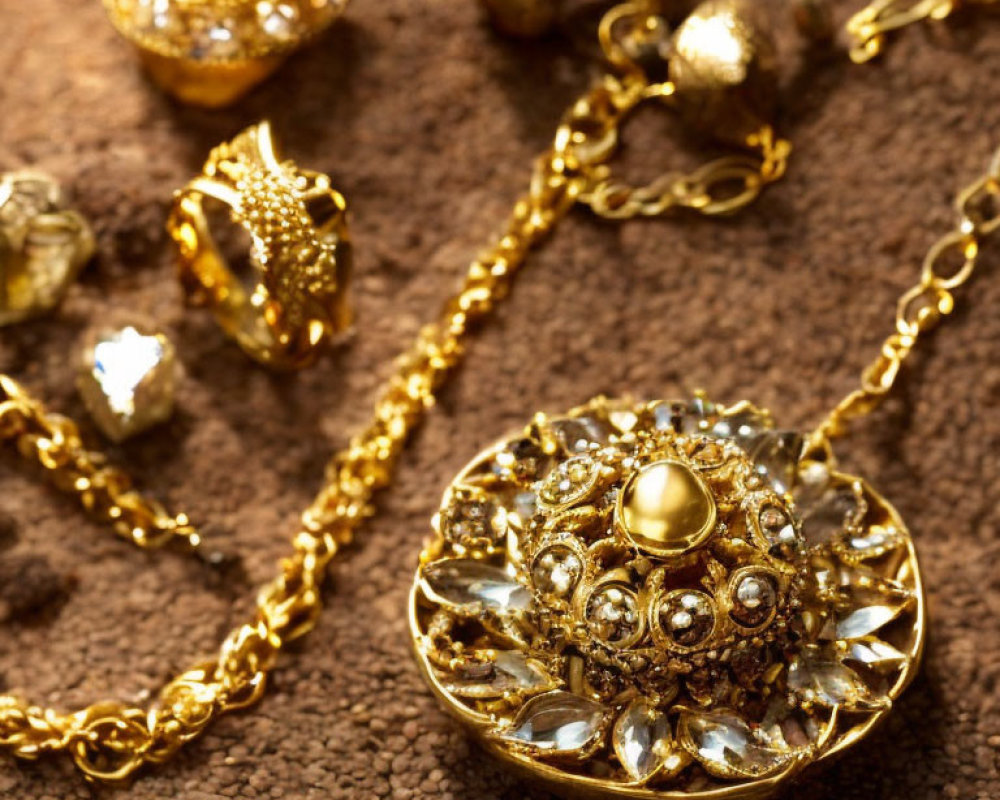 Ornate Gold Jewelry with Gemstones on Textured Surface