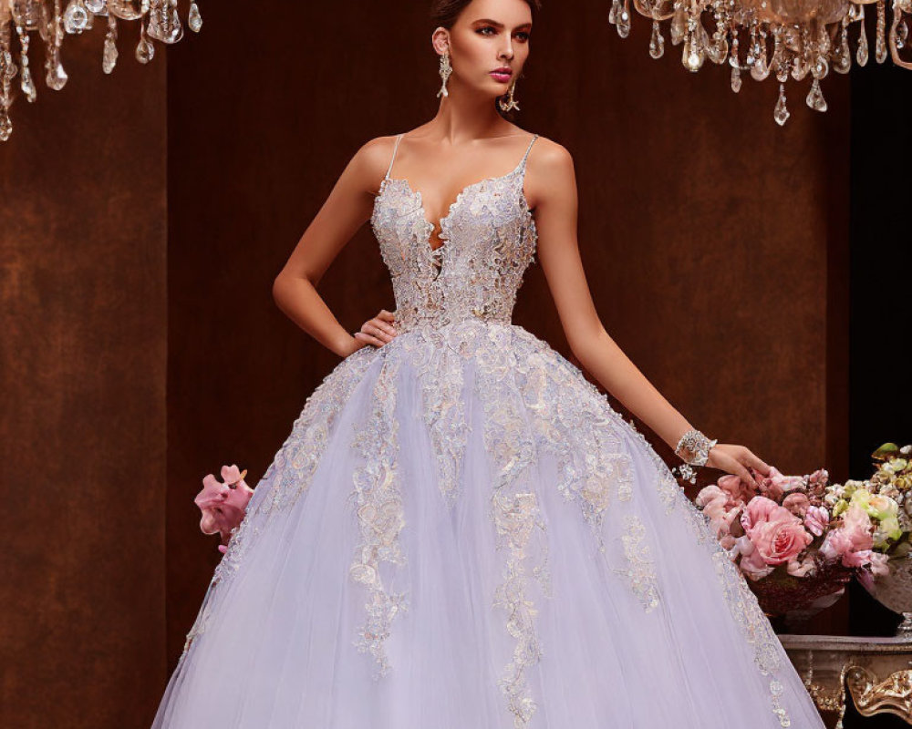 Bridal gown with lace detailing and bouquet under chandeliers