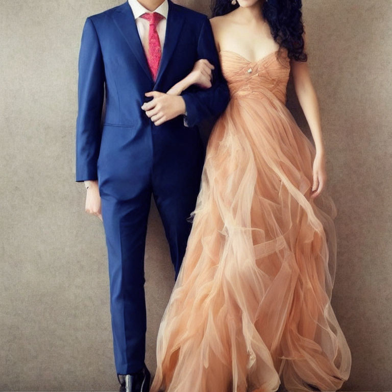 Man in Blue Suit and Woman in Peach Gown Posed Together