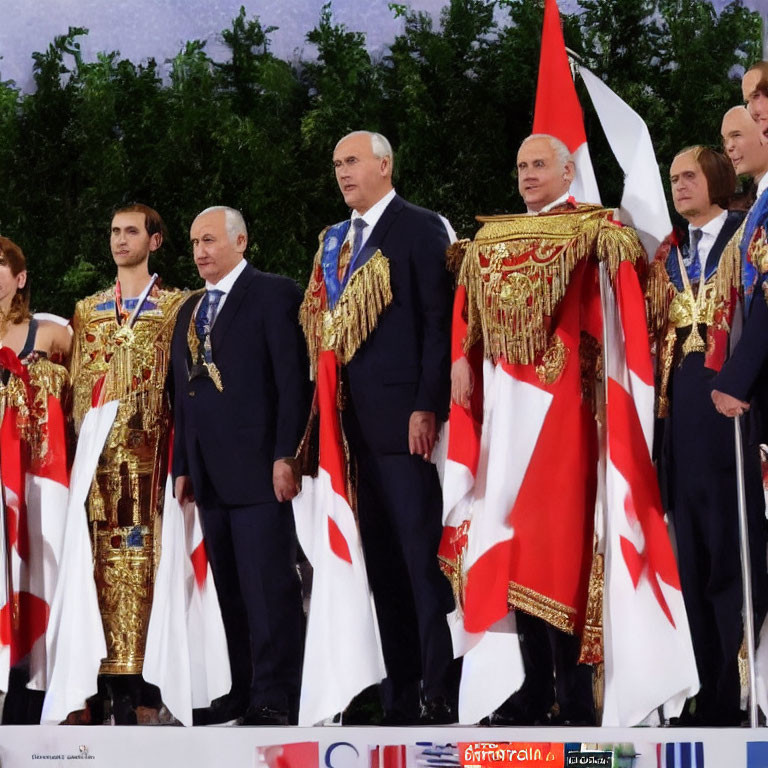 Elaborately dressed individuals with awards on podium with flags