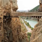 Scenic landscape: bridge over river, mountains, autumn trees, rock formations