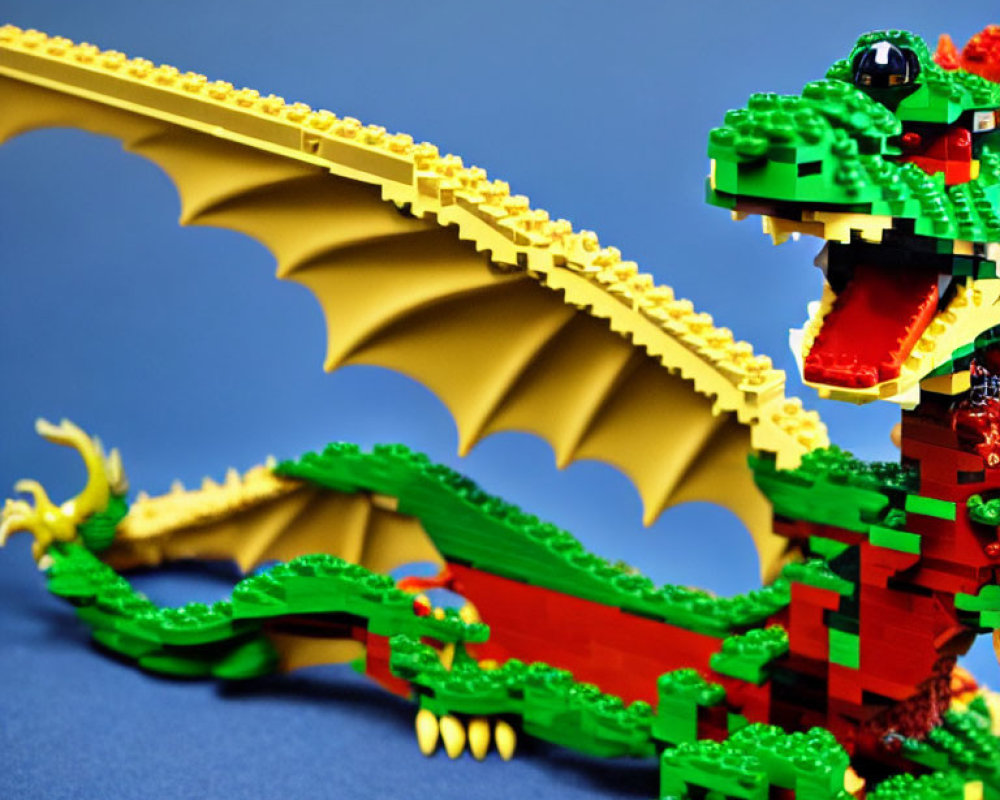 Colorful Lego Dragon with Green Body and Red Wings on Blue Background