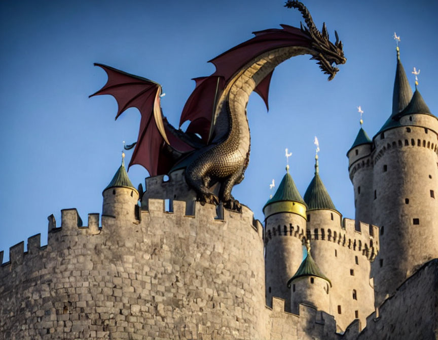 Dragon sculpture on medieval castle under blue sky