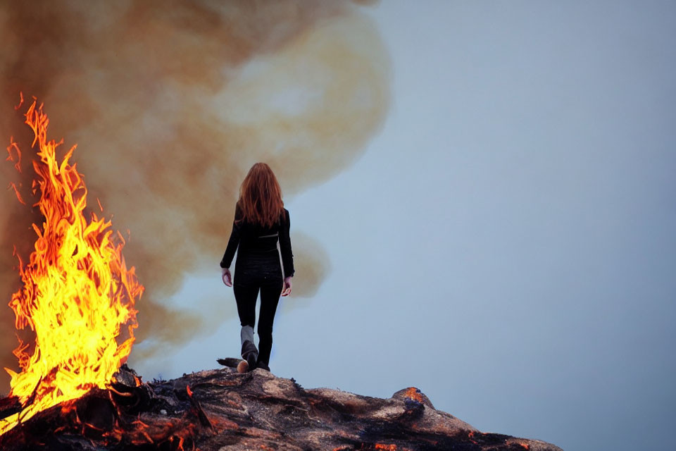 Long-Haired Person Walking Towards Smoke and Flame Outdoors
