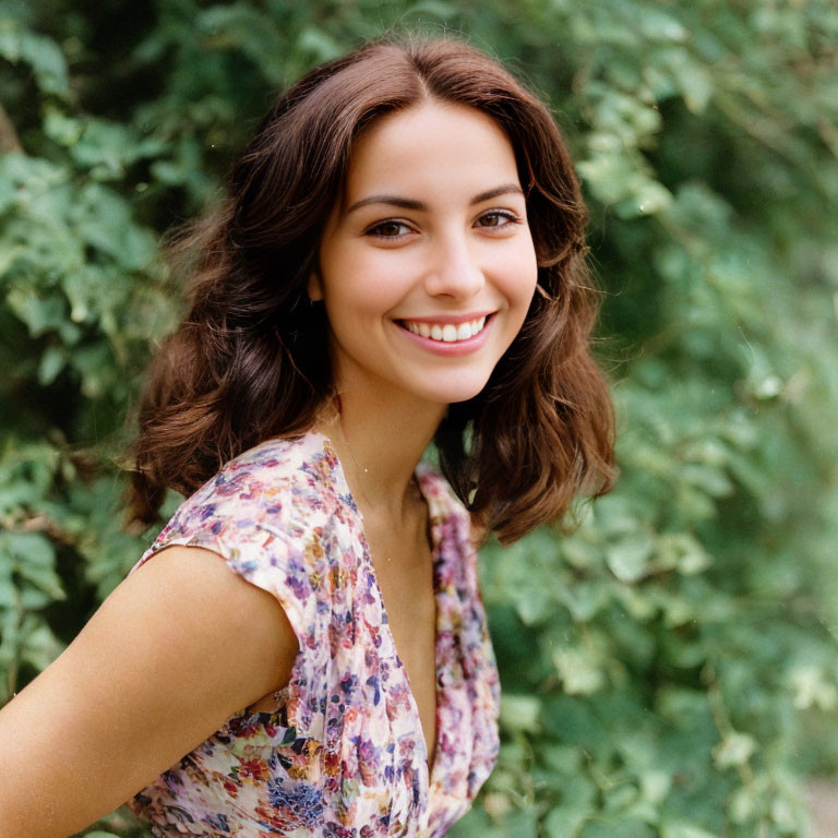 Smiling woman with brown hair in floral dress outdoors