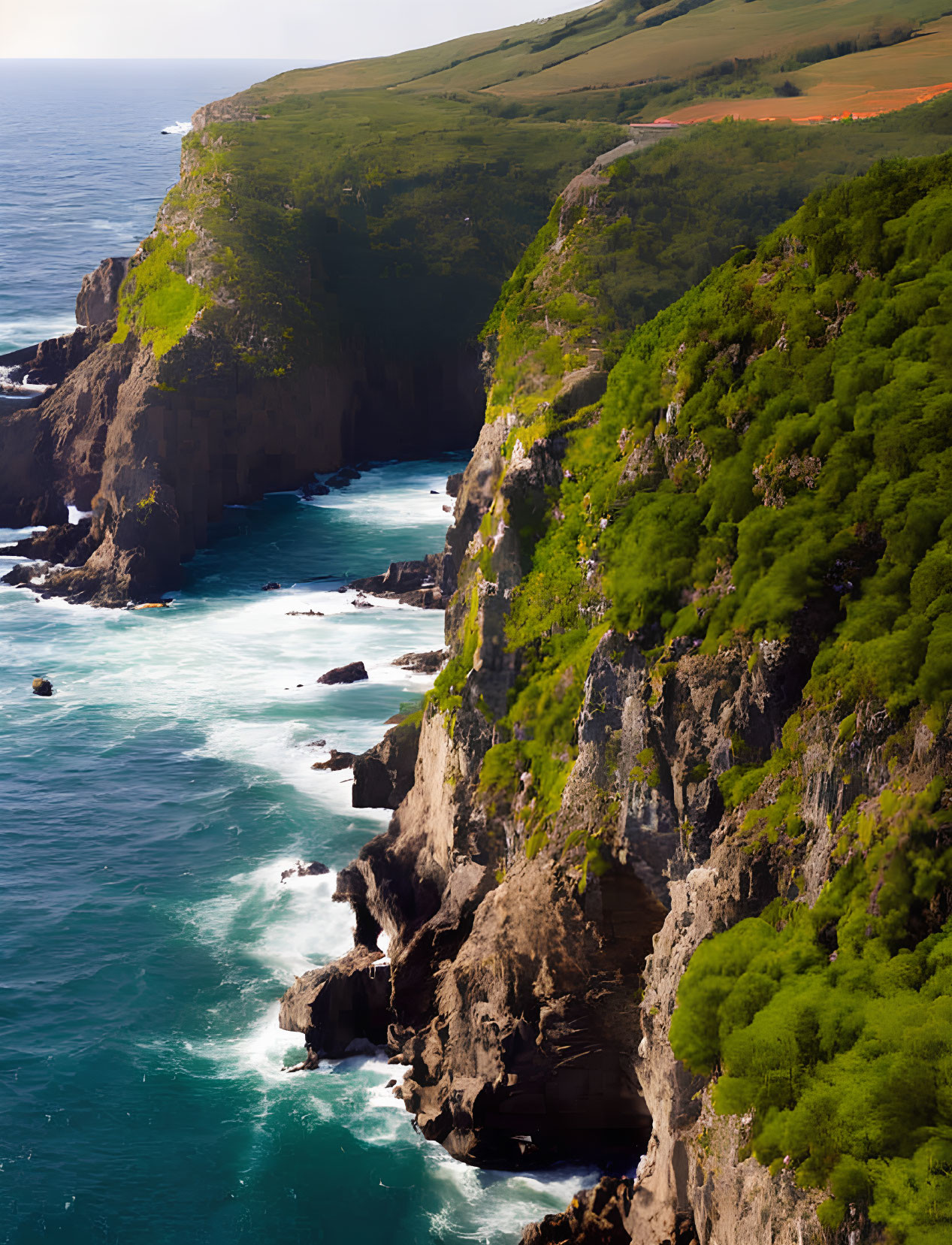 Steep cliffs and turquoise sea with crashing waves