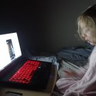 Child with Glasses Using Computer in Neon Lit Room