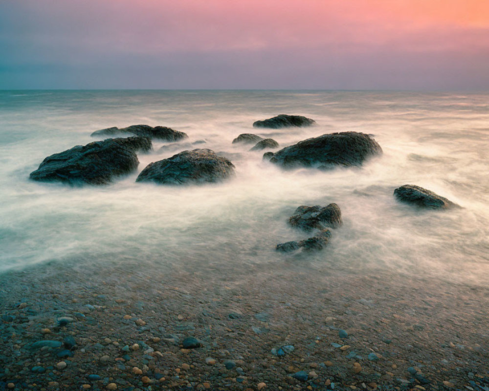 Tranquil coastal dusk scene with misty water and pastel sky