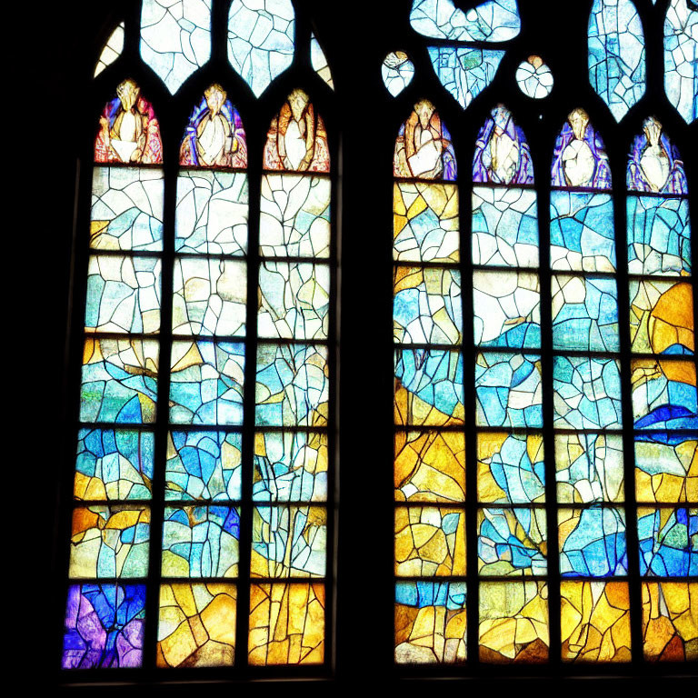 Colorful stained glass window with abstract shapes and figures in blue, yellow, and purple hues